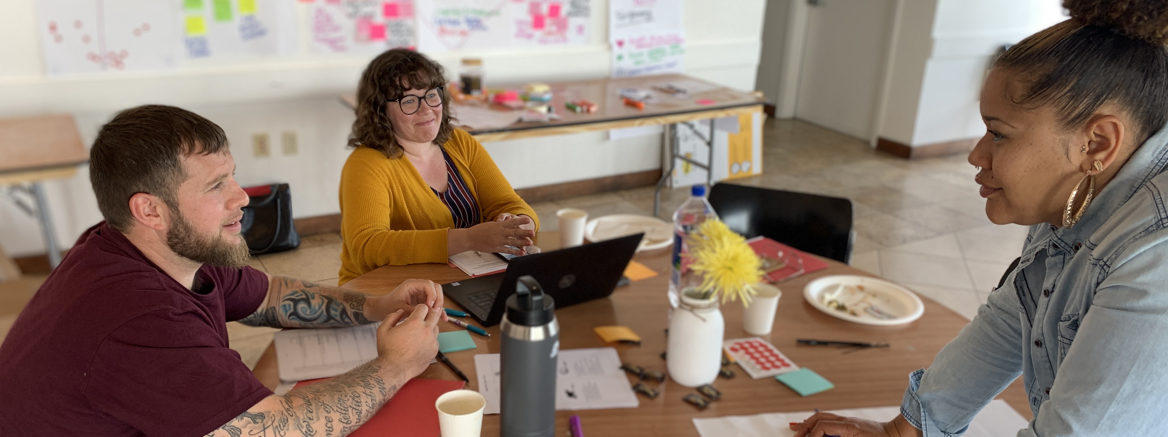 ALL IN Staff Members - Ryan Thayer, Jessica Blakemore, and Hannah Moore - gather around a table during a strategic planning meeting.